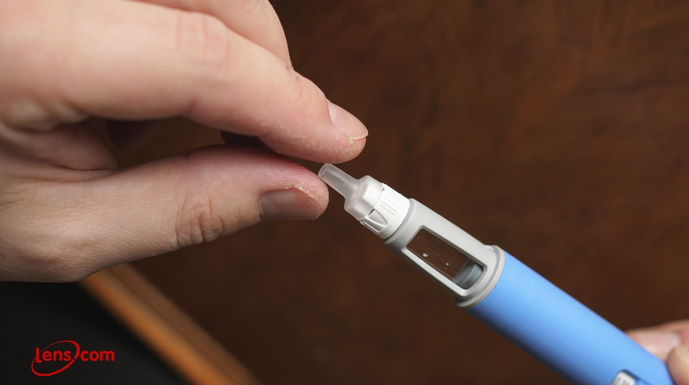Person preparing an insulin pen by attaching a new needle tip.