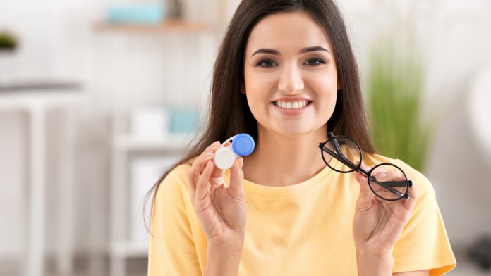 woman-holding-contact-lens-case-and-eyeglasses