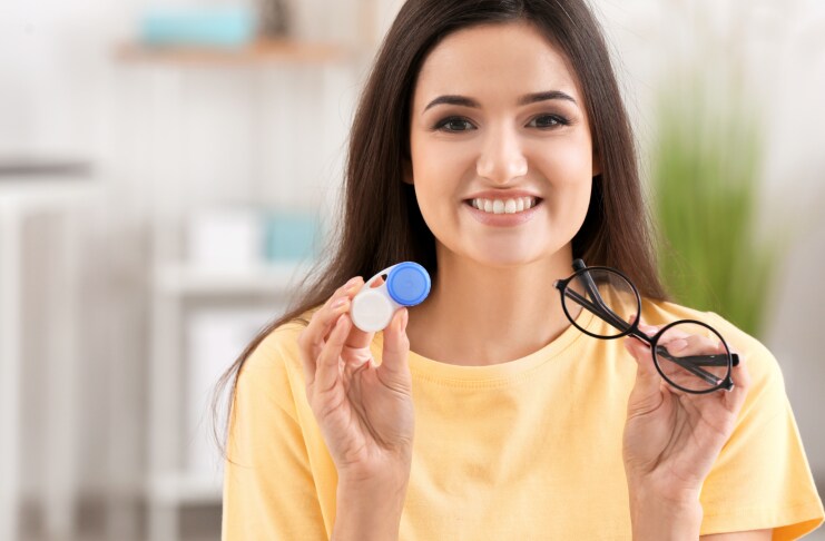 woman-holding-contact-lens-case-and-eyeglasses