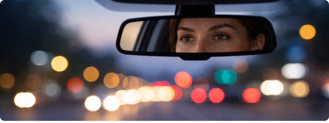 Driver at dusk with city lights softly blurred, suggesting low light vision clarity.