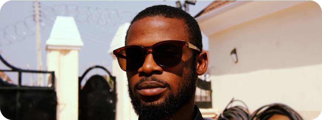 A handsome man nonchalantly wearing UV protecting sunglasses.