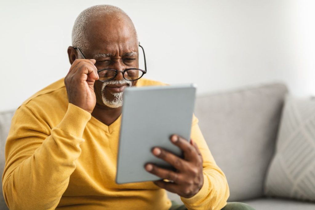 senior-man-with-poor-eyesight-using-tablet-squinting