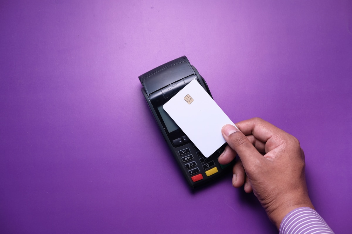 Credit card being scanned on a violet background. 