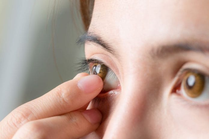 close-up shot of young woman wearing or removing contact lens